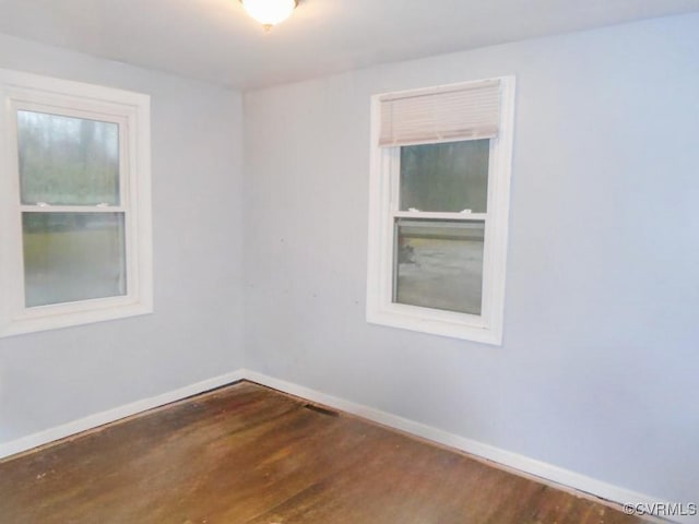 empty room with baseboards and wood finished floors