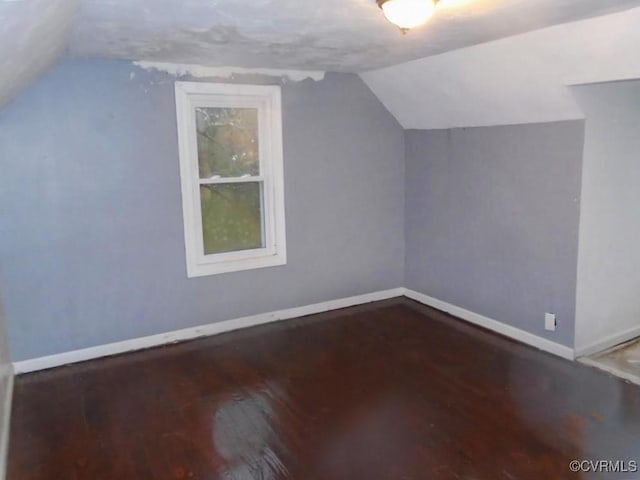 bonus room with vaulted ceiling, baseboards, and wood finished floors