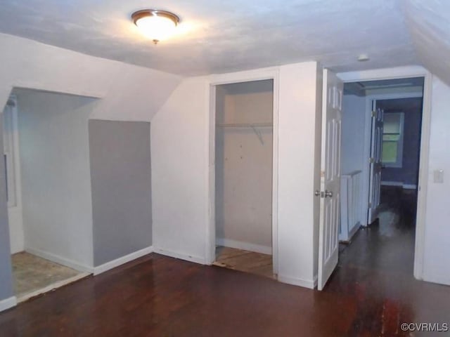 interior space featuring lofted ceiling, a closet, and baseboards