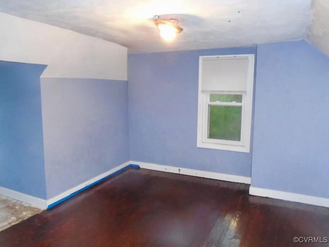 bonus room featuring vaulted ceiling, hardwood / wood-style flooring, and baseboards