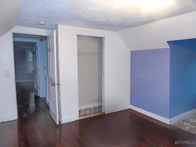 additional living space with lofted ceiling, wood finished floors, and baseboards