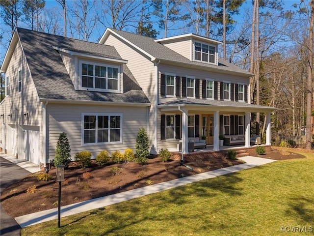 colonial home featuring a patio, a garage, a shingled roof, an outdoor living space, and a front lawn