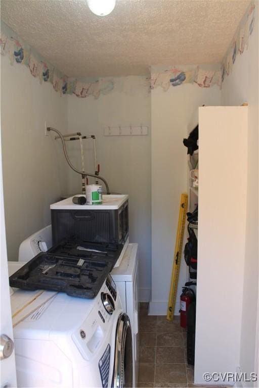 laundry room featuring tile patterned flooring, laundry area, separate washer and dryer, and a textured ceiling