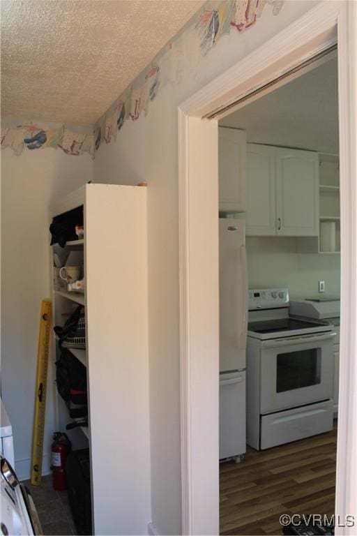 kitchen with white appliances, dark wood-style flooring, and a textured ceiling