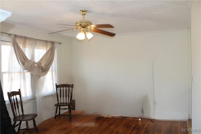 spare room with a ceiling fan, wood finished floors, and a textured ceiling