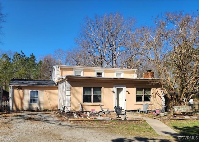 view of front of home with a chimney and stucco siding