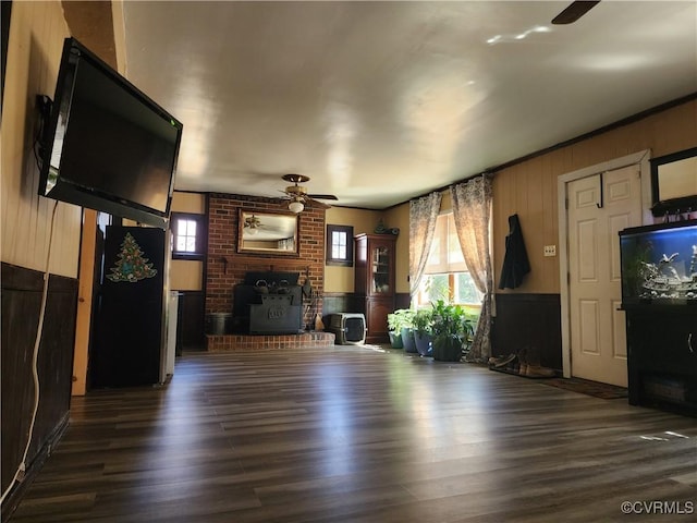 unfurnished living room featuring a fireplace, ceiling fan, and wood finished floors