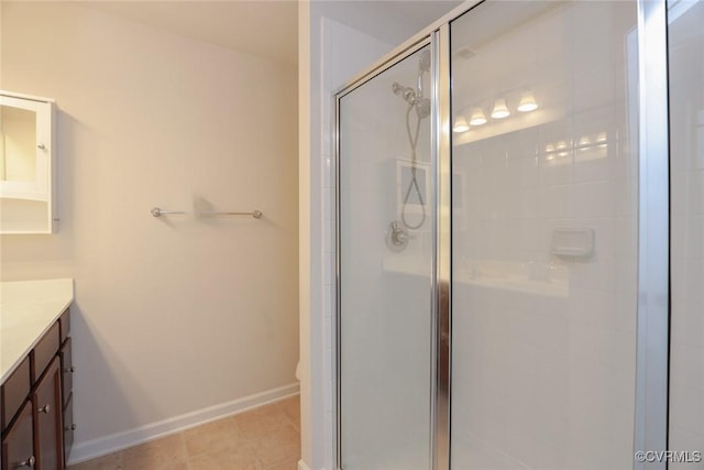 bathroom featuring a stall shower, baseboards, toilet, tile patterned flooring, and vanity