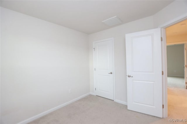 unfurnished bedroom featuring light carpet and baseboards