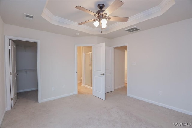 unfurnished bedroom with ornamental molding, a raised ceiling, visible vents, and baseboards