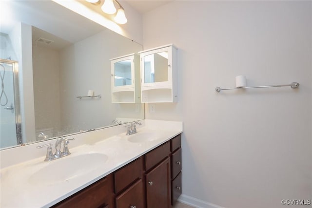 bathroom with double vanity, an enclosed shower, a sink, and visible vents