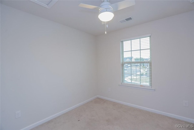 empty room with light carpet, a ceiling fan, visible vents, and baseboards