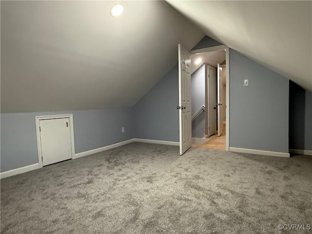 bonus room featuring lofted ceiling, carpet floors, and baseboards