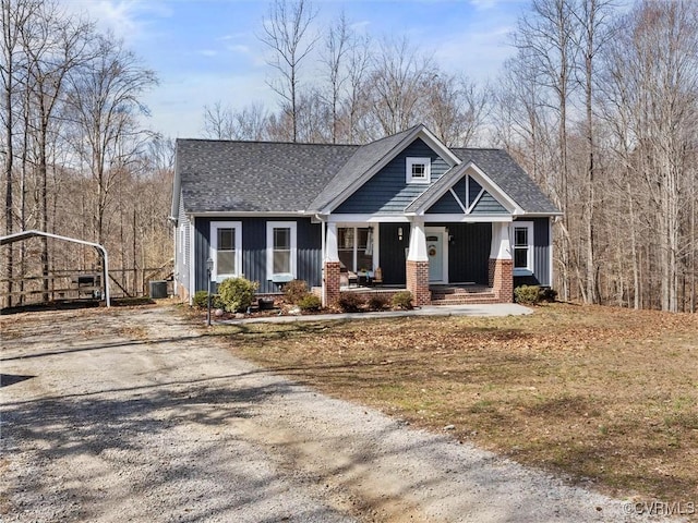 craftsman-style home with brick siding, board and batten siding, central air condition unit, covered porch, and driveway