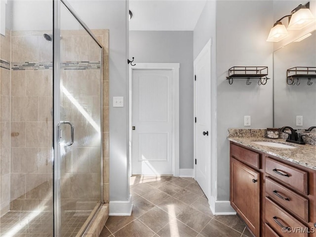 full bathroom with vanity, baseboards, a stall shower, and tile patterned flooring