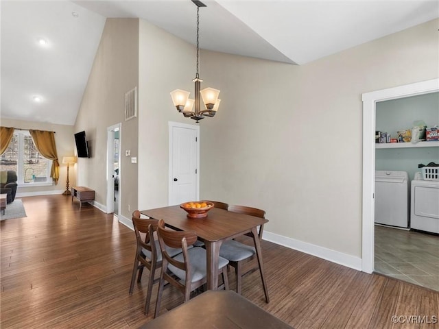 dining room with baseboards, a notable chandelier, wood finished floors, and washing machine and clothes dryer