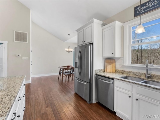 kitchen featuring visible vents, a sink, dark wood finished floors, stainless steel appliances, and lofted ceiling