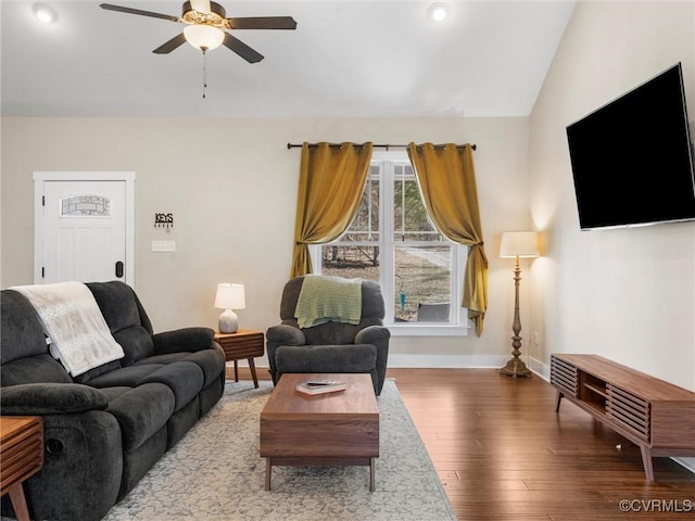 living area featuring baseboards, wood finished floors, a ceiling fan, and vaulted ceiling