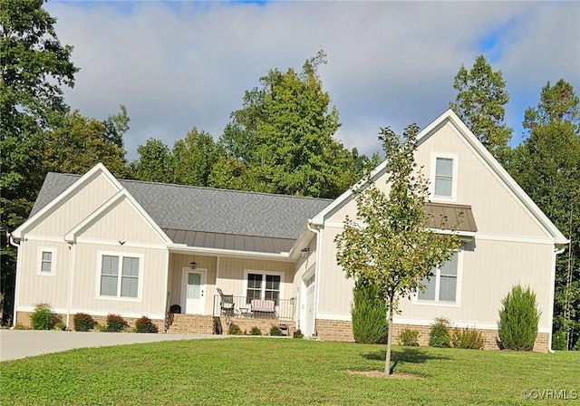 modern farmhouse style home with a front yard, a standing seam roof, a porch, a shingled roof, and metal roof