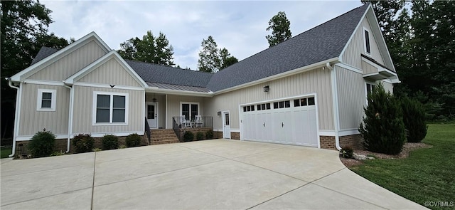 view of front of home with covered porch, concrete driveway, a garage, and roof with shingles