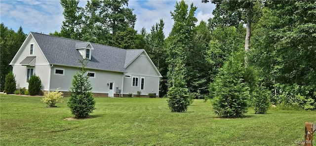 view of home's exterior with a lawn and a shingled roof