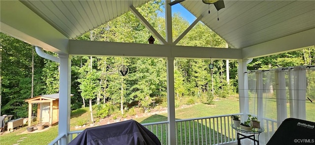 sunroom with vaulted ceiling, a ceiling fan, and a wealth of natural light