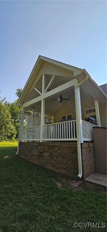 view of side of home featuring a porch and a lawn