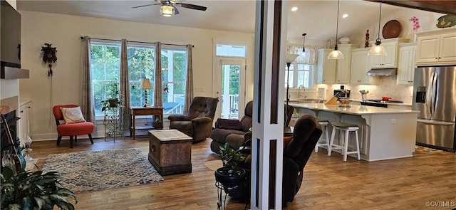 living area featuring wood finished floors, a fireplace, recessed lighting, ceiling fan, and vaulted ceiling