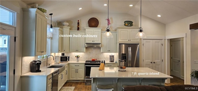 kitchen with under cabinet range hood, a breakfast bar, light countertops, appliances with stainless steel finishes, and a sink