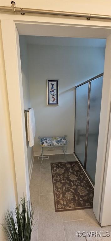 bathroom with tile patterned flooring and a shower with door