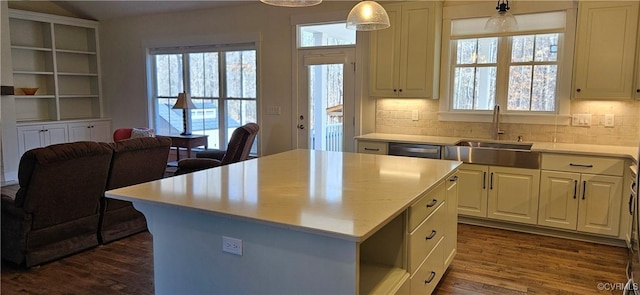 kitchen with a sink, dishwashing machine, dark wood-style flooring, and light countertops