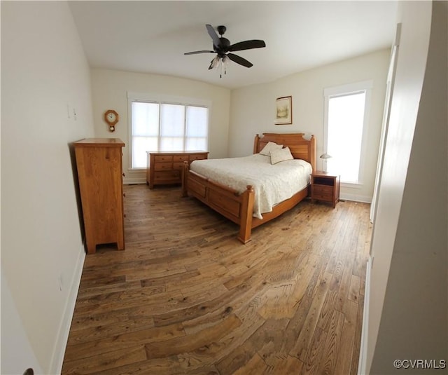 bedroom featuring baseboards, a ceiling fan, and hardwood / wood-style flooring