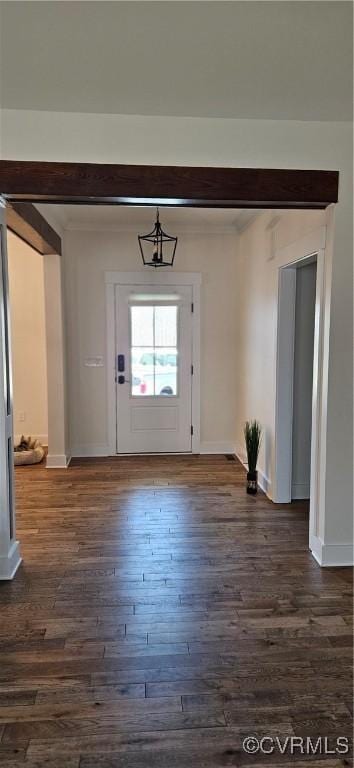 entrance foyer featuring dark wood-style floors, baseboards, and ornamental molding