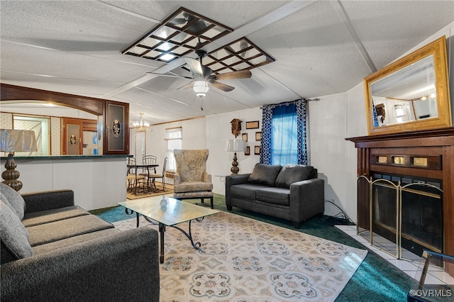 living area with a fireplace with flush hearth, plenty of natural light, ceiling fan, and vaulted ceiling