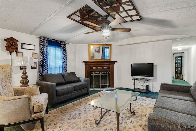 living room with lofted ceiling, a ceiling fan, a fireplace, and a textured ceiling