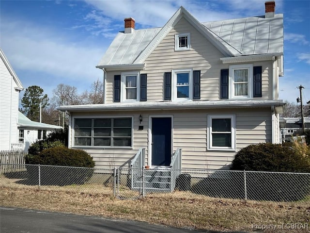 view of front of property featuring a fenced front yard, entry steps, metal roof, and a chimney