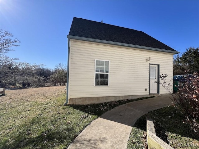 view of side of home with roof with shingles