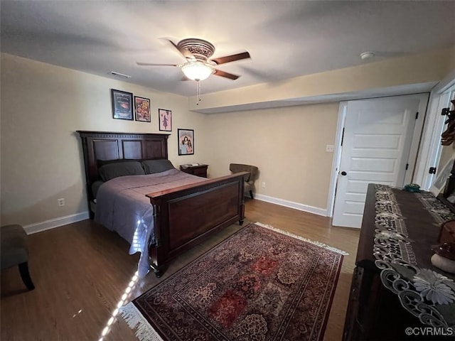 bedroom featuring ceiling fan, visible vents, baseboards, and wood finished floors