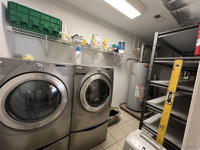 laundry area featuring gas water heater, laundry area, visible vents, tile patterned floors, and washer and clothes dryer