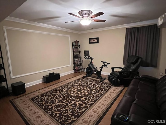 home theater featuring wood finished floors, crown molding, baseboards, and ceiling fan