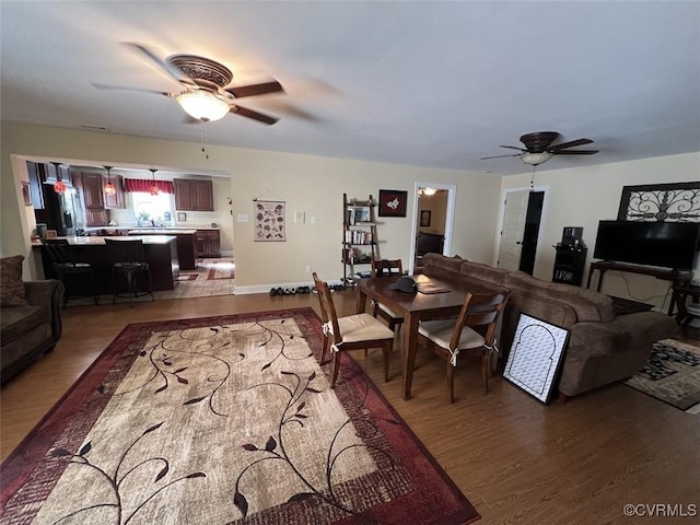 living room with a ceiling fan and dark wood finished floors