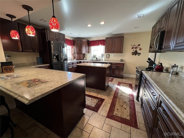 kitchen featuring a peninsula, range with electric stovetop, refrigerator with ice dispenser, light countertops, and stainless steel microwave