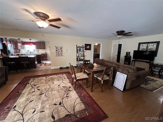 living room with a ceiling fan and dark wood finished floors