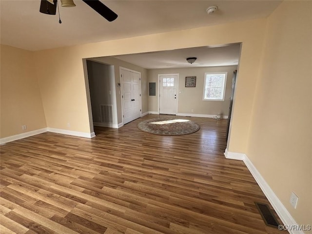 entryway with wood finished floors, a ceiling fan, visible vents, baseboards, and electric panel