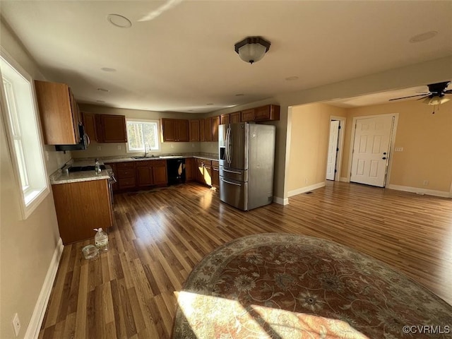 kitchen featuring stainless steel fridge, baseboards, light countertops, and dishwasher