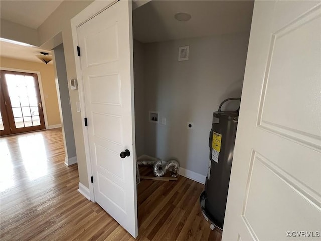 laundry area with hookup for a washing machine, electric water heater, wood finished floors, visible vents, and electric dryer hookup