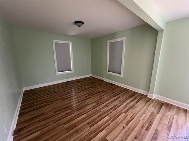 empty room featuring wood finished floors and baseboards