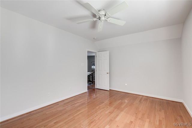 empty room with lofted ceiling, ceiling fan, light wood-style flooring, and baseboards