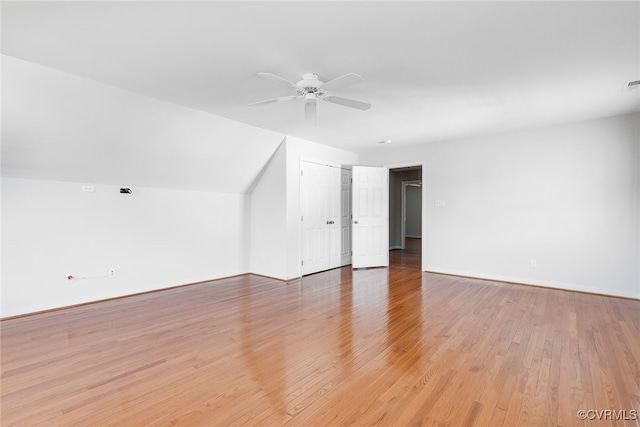 additional living space with lofted ceiling, visible vents, a ceiling fan, baseboards, and light wood finished floors