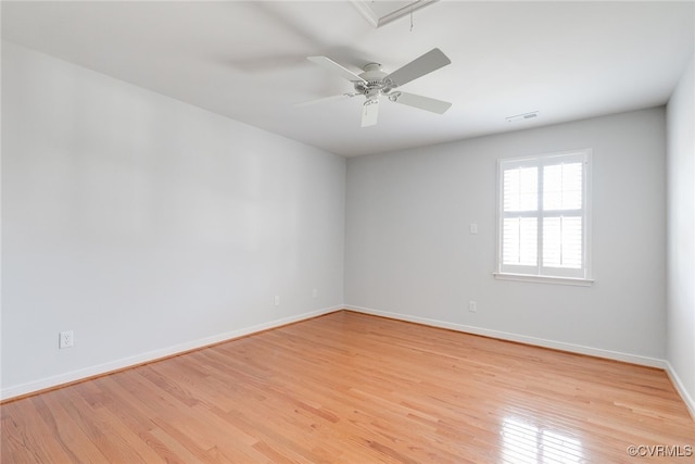 unfurnished room featuring attic access, visible vents, baseboards, a ceiling fan, and light wood-style flooring